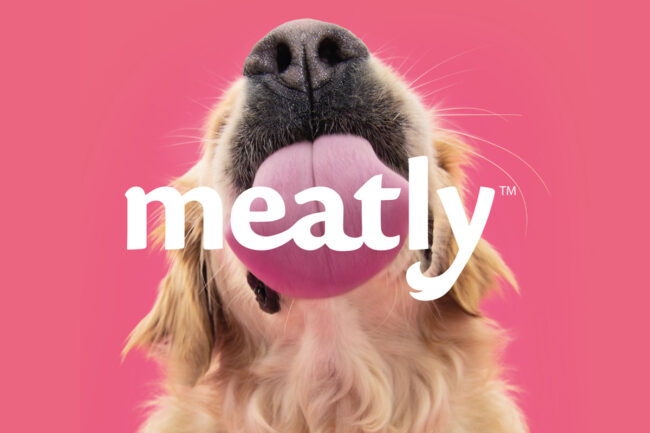 Dog licking Meatly's logo